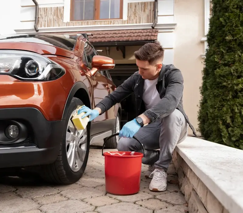 Lavage auto à domicile Asnières-sur-Nouère : professionnel intervenant sur un véhicule